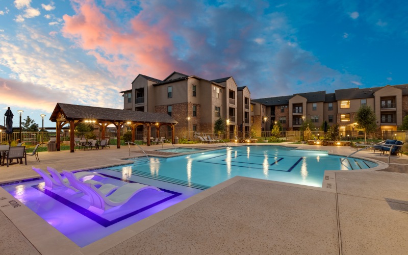 a pool lit up with the twilight sky