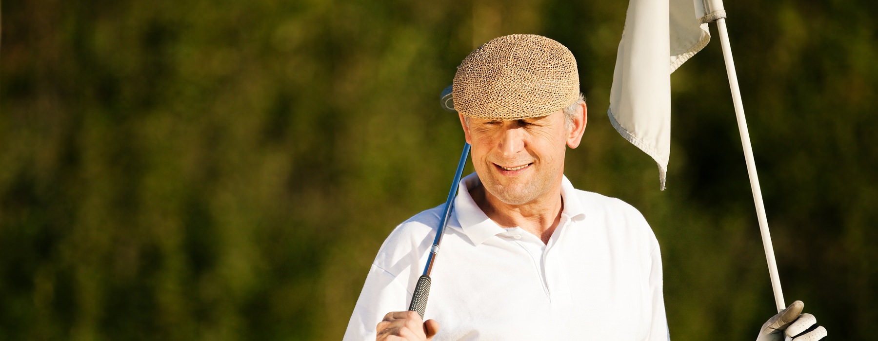 older man hold a golf club and hole flag on golf course